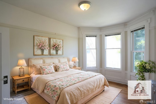 bedroom with multiple windows and dark hardwood / wood-style flooring