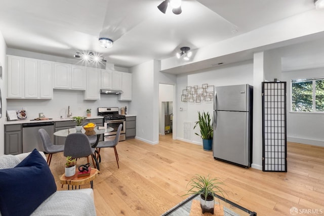 kitchen featuring sink, ceiling fan, stainless steel appliances, white cabinets, and light wood-type flooring