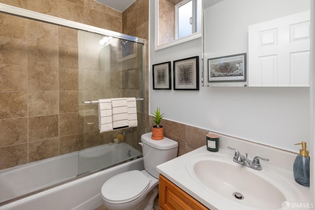 full bathroom featuring enclosed tub / shower combo, vanity, and toilet