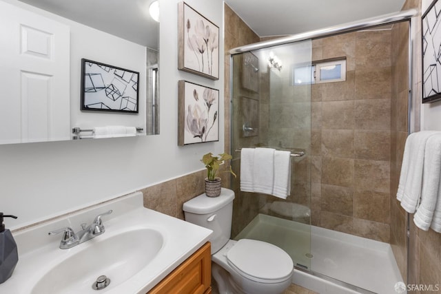 bathroom featuring vanity, toilet, and a shower with door