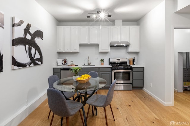 kitchen featuring sink, light hardwood / wood-style flooring, appliances with stainless steel finishes, white cabinetry, and gray cabinetry