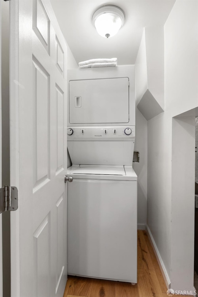 washroom featuring stacked washing maching and dryer and light hardwood / wood-style floors