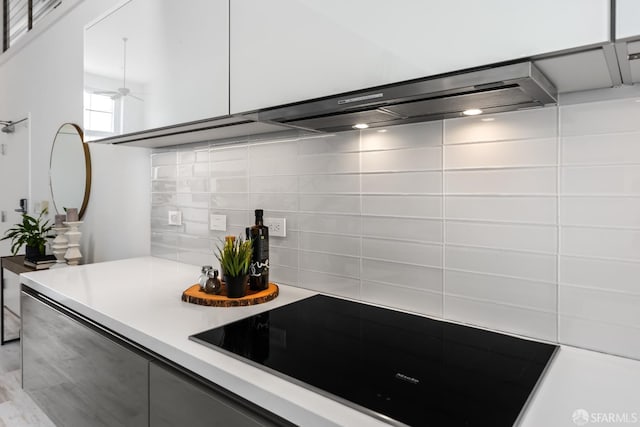 229 8th St Unit 3, San Francisco, CA 94103 - kitchen with black electric cooktop, decorative backsplash, light countertops, ceiling fan, and modern cabinets