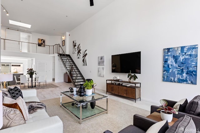 229 8th St Unit 3, San Francisco, CA 94103 - living room with a high ceiling, stairs, wood finished floors, and a skylight