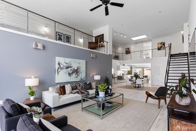 229 8th St Unit 3, San Francisco, CA 94103 - living room featuring a high ceiling, a ceiling fan, wood finished floors, track lighting, and stairs