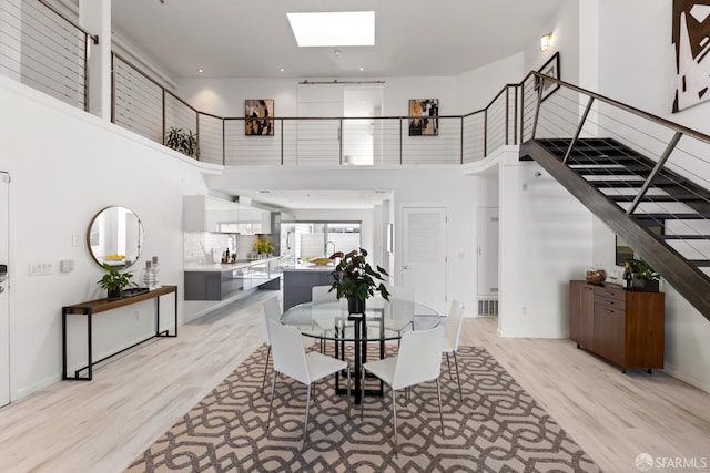 229 8th St Unit 3, San Francisco, CA 94103 - dining area with a towering ceiling, stairway, a skylight, and light wood-type flooring
