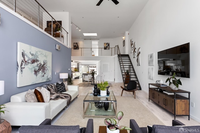 229 8th St Unit 3, San Francisco, CA 94103 - living area featuring stairs, a towering ceiling, a ceiling fan, wood finished floors, and track lighting