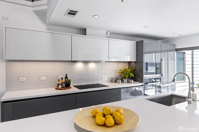 229 8th St Unit 3, San Francisco, CA 94103 - kitchen featuring black electric cooktop, modern cabinets, tasteful backsplash, light countertops, and recessed lighting