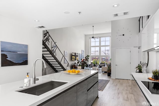 229 8th St Unit 3, San Francisco, CA 94103 - kitchen featuring gray cabinets, a towering ceiling, light wood-style floors, light countertops, and recessed lighting