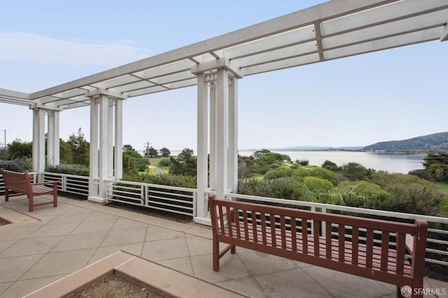 view of patio / terrace with a water view and a pergola