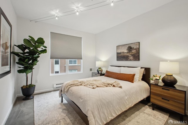 bedroom with rail lighting and a baseboard heating unit