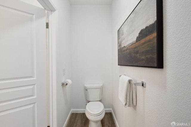 bathroom with toilet and hardwood / wood-style floors