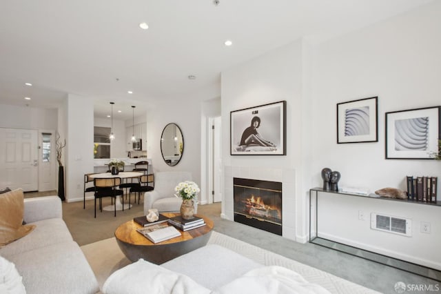 living room featuring light colored carpet and a fireplace