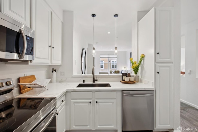 kitchen featuring sink, light stone countertops, white cabinets, and appliances with stainless steel finishes