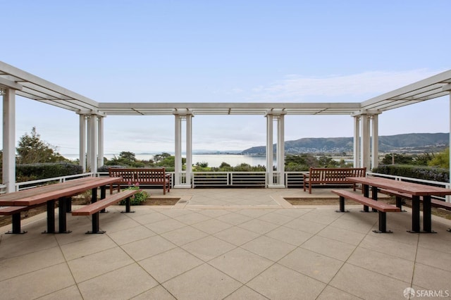 view of patio / terrace with a water and mountain view