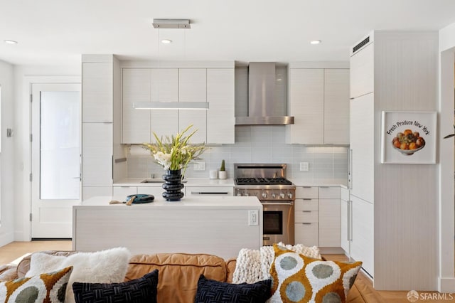 392 Corbett Ave, San Francisco, CA 94114 - kitchen featuring stainless steel stove, wall chimney range hood, modern cabinets, light countertops, and tasteful backsplash