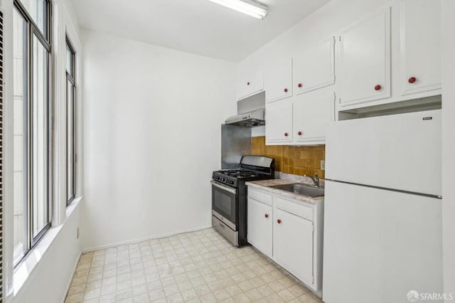 28-30 Sonoma St, San Francisco, CA 94133 - kitchen with freestanding refrigerator, stainless steel gas stove, under cabinet range hood, a sink, and light flooring