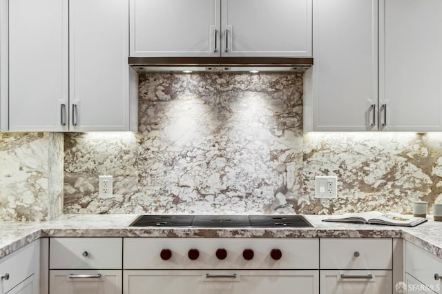 kitchen with backsplash, stainless steel gas stovetop, and white cabinets