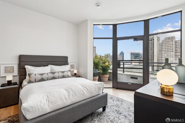 bedroom with access to exterior and light hardwood / wood-style flooring