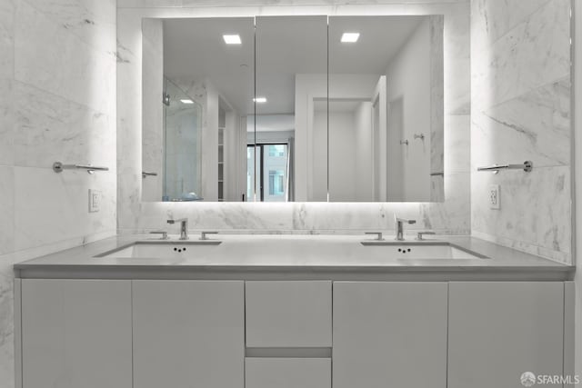 bathroom with tile walls, an enclosed shower, and vanity