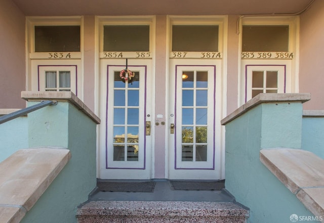 entrance to property with a porch and stucco siding