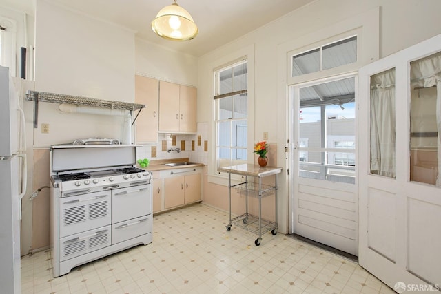 kitchen with backsplash, a sink, light countertops, light floors, and white appliances