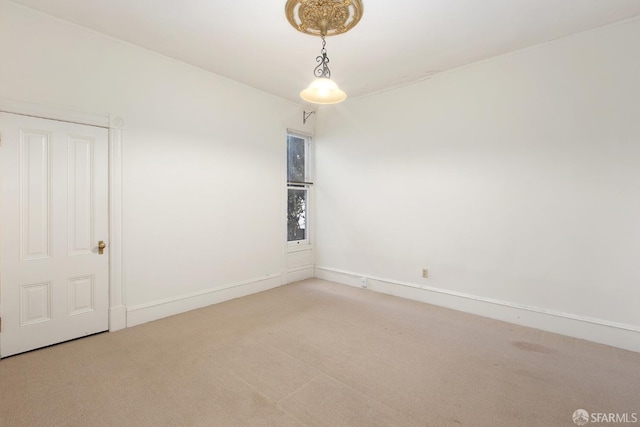 spare room featuring baseboards and carpet