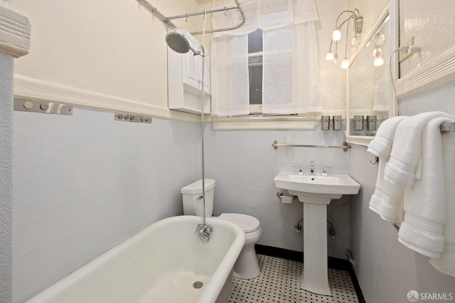 full bath featuring a freestanding bath, baseboards, and toilet