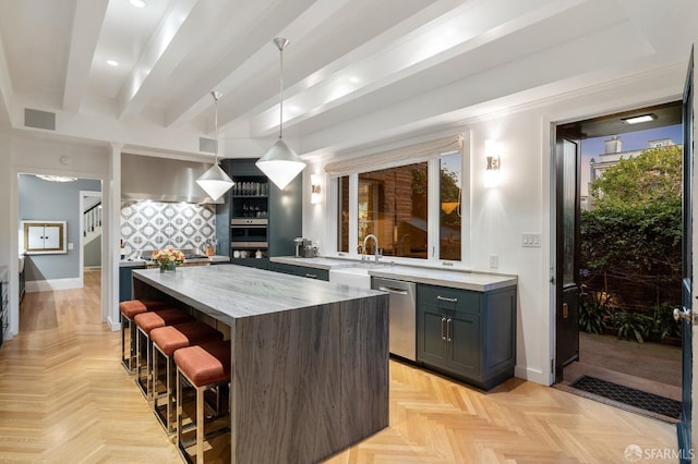 kitchen featuring visible vents, beamed ceiling, a kitchen bar, stainless steel dishwasher, and a sink