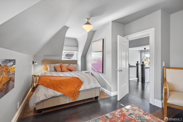 bedroom featuring cooling unit, baseboards, concrete floors, and vaulted ceiling