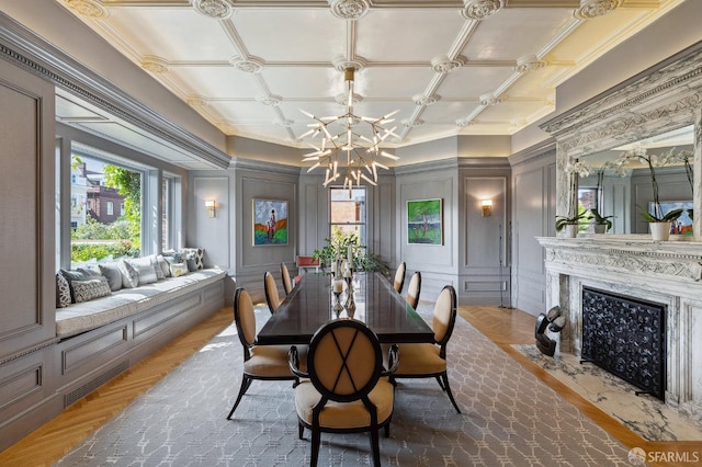 dining room featuring a notable chandelier, a fireplace, and a decorative wall