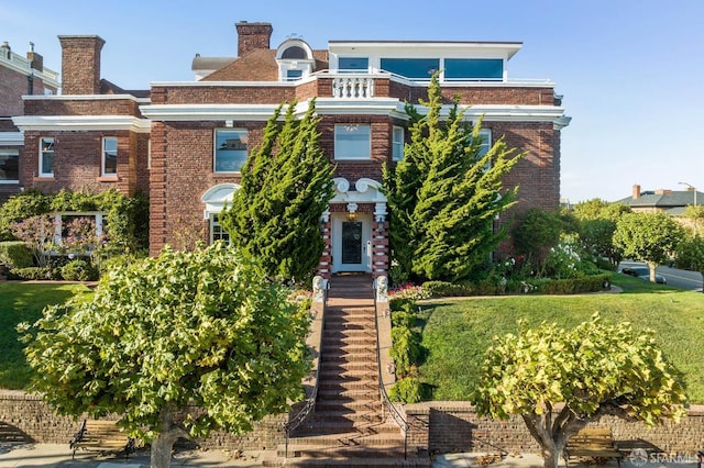 view of front of home featuring a front yard and brick siding