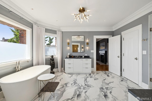 full bathroom with a freestanding bath, marble finish floor, a chandelier, and crown molding