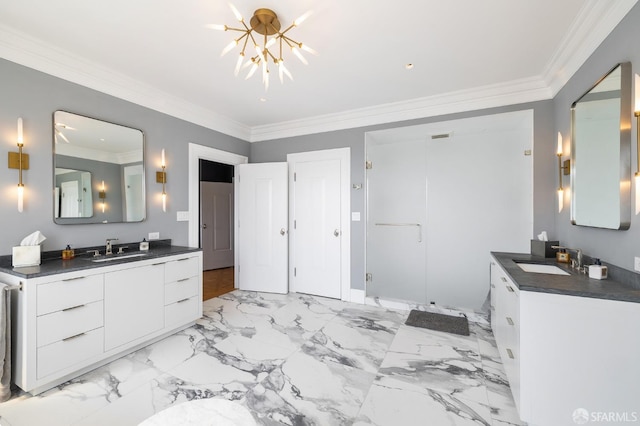 bathroom featuring crown molding, two vanities, a chandelier, and a sink