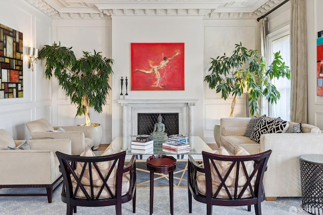 living area with a decorative wall, a fireplace, and ornamental molding