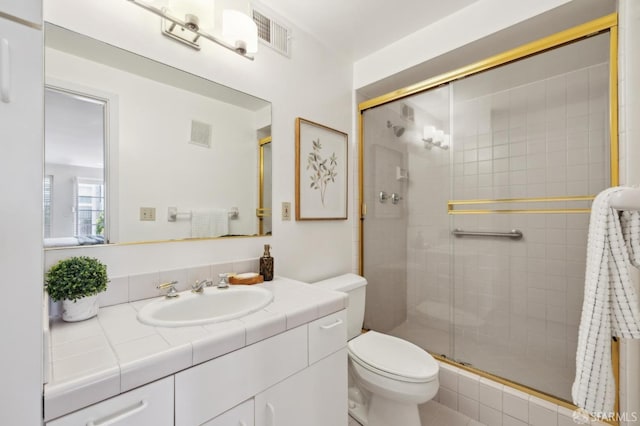 full bath featuring toilet, a stall shower, and vanity