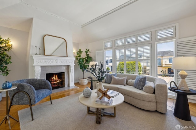 living room featuring a high end fireplace, wood finished floors, and baseboards