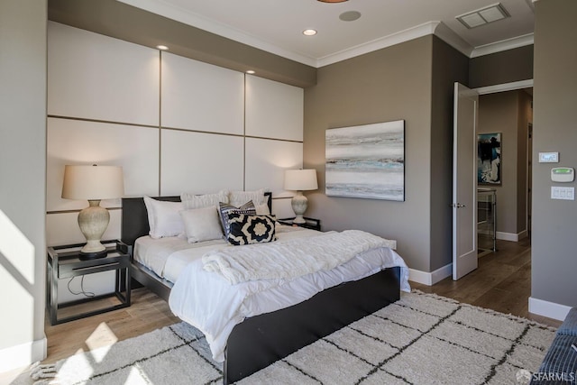 bedroom with visible vents, crown molding, and wood finished floors