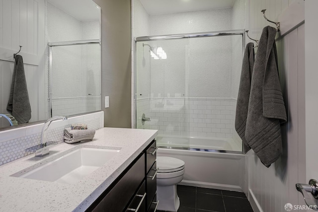 bathroom featuring shower / bath combination with glass door, vanity, toilet, and tile patterned floors