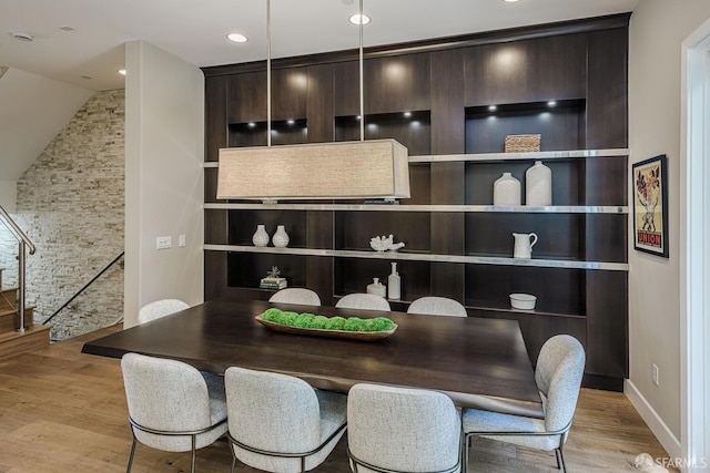 dining room featuring recessed lighting, light wood-style flooring, and stairs