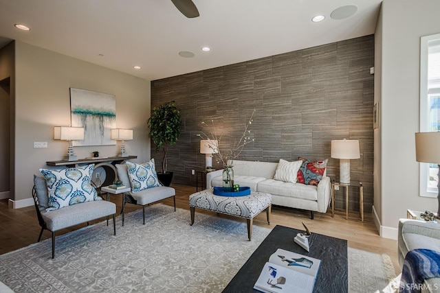 living area featuring an accent wall, recessed lighting, and wood finished floors