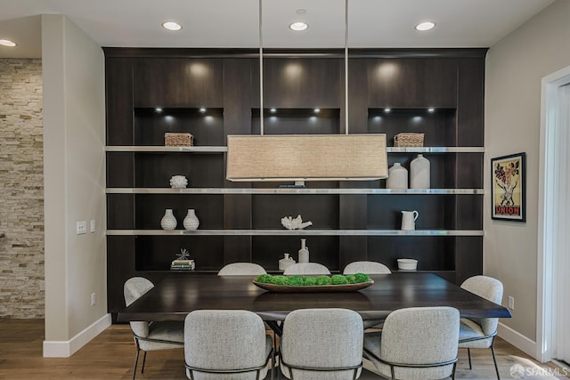 dining area featuring baseboards, wood finished floors, and recessed lighting