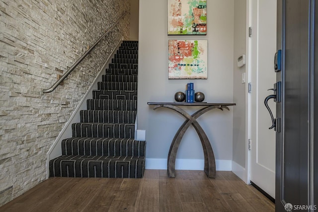 foyer with stairs, baseboards, and wood finished floors