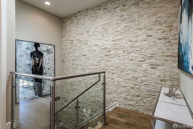 hallway featuring an upstairs landing and wood finished floors