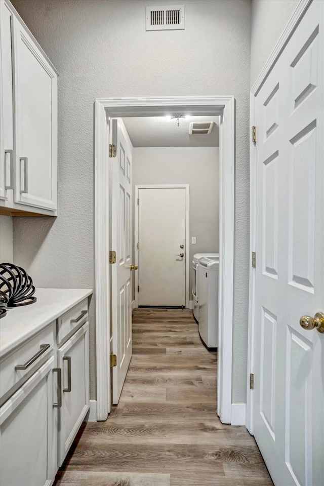 hall featuring washer and clothes dryer and light hardwood / wood-style floors