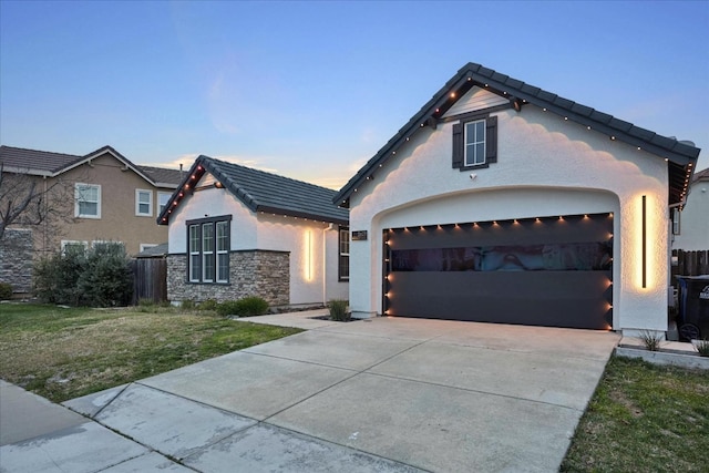 view of front of property featuring a garage and a lawn