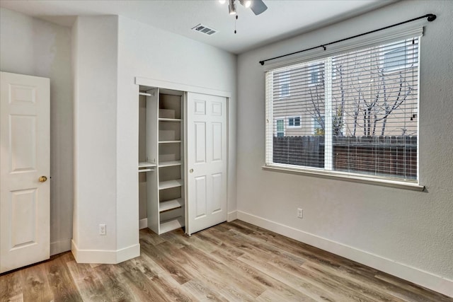 unfurnished bedroom featuring wood-type flooring, ceiling fan, and a closet