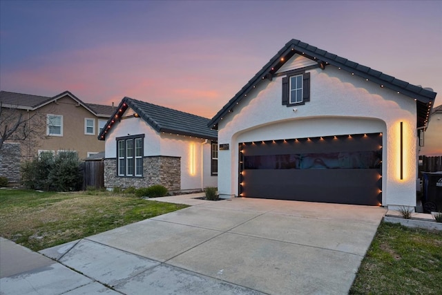 view of front of home with a garage and a lawn