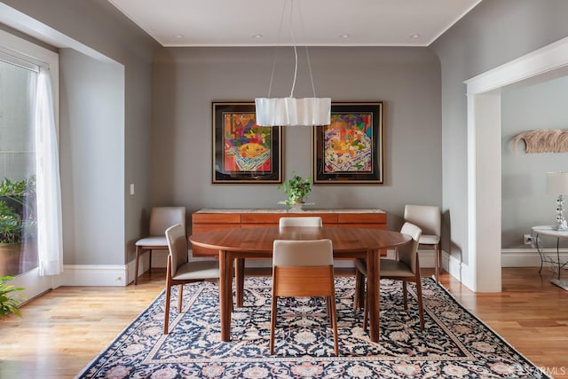 dining area with baseboards and light wood finished floors