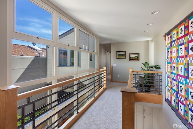 hall featuring carpet floors, baseboards, recessed lighting, and an upstairs landing